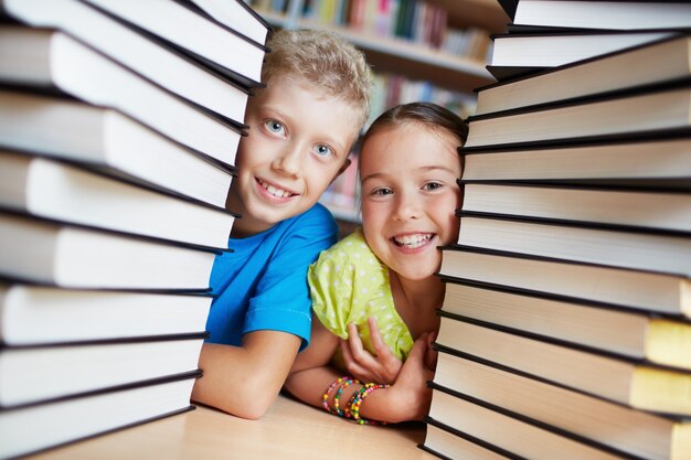 Compañeros de clase escondidos detrás de los libros