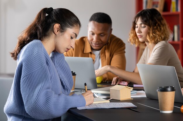 Compañeros de clase escribiendo y aprendiendo durante la sesión de estudio.