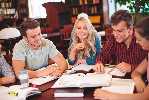 Compañeros de clase estudiando juntos en la biblioteca.