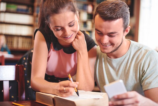 Compañeros de clase estudiando juntos en la biblioteca.