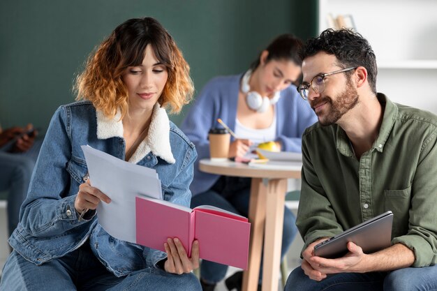 Compañeros de clase leyendo y aprendiendo de internet y notas.