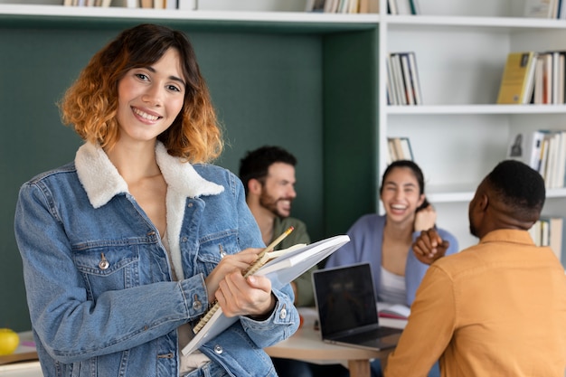 Compañeros de clase leyendo y aprendiendo de notas y portátiles.