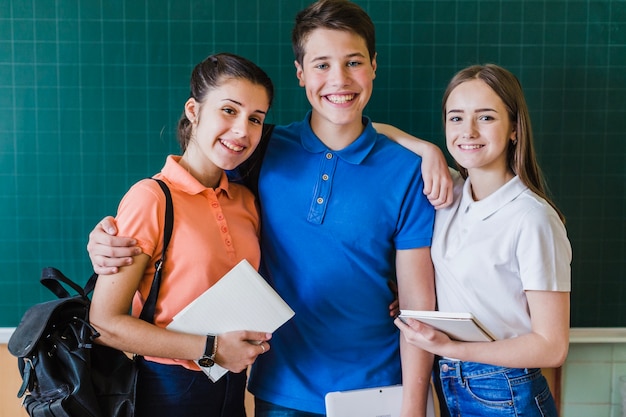 Foto gratuita compañeros de clase posando con la pizarra