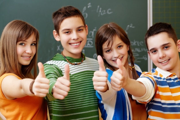 Foto gratuita compañeros de clase con el pulgar hacia arriba en un aula