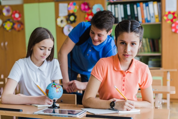 Compañeros de clase sentados en sus pupitres