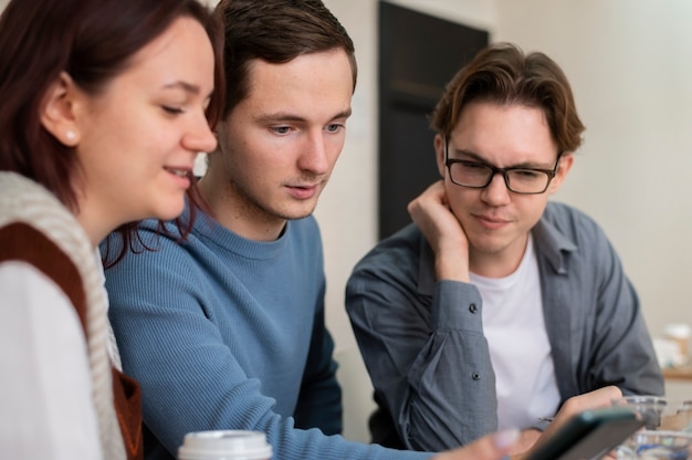 Compañeros de clase con smartphone durante el estudio en grupo