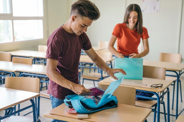 Compañeros de clase sonrientes preparando sus materiales