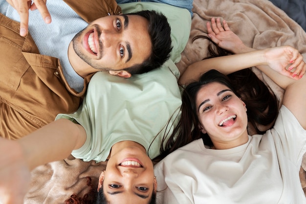 Compañeros de cuarto sonrientes acostados juntos vista superior