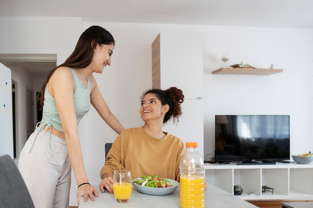 Foto gratuita compañeros de cuarto sonrientes de tiro medio en casa