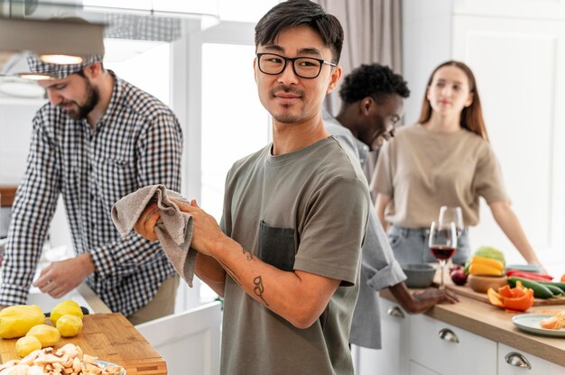 Compañeros de cuarto de tiro medio cocinando en casa