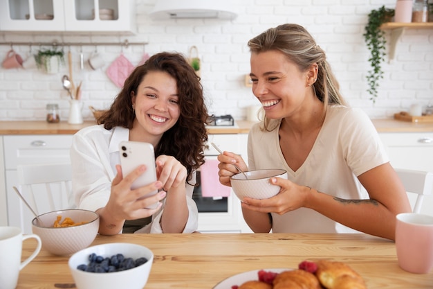 Foto gratuita compañeros de cuarto de tiro medio mirando smartphone