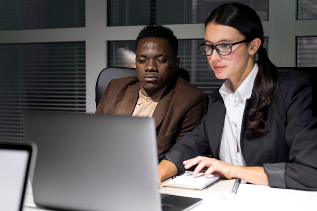 Compañeros de equipo de negocios trabajando hasta tarde