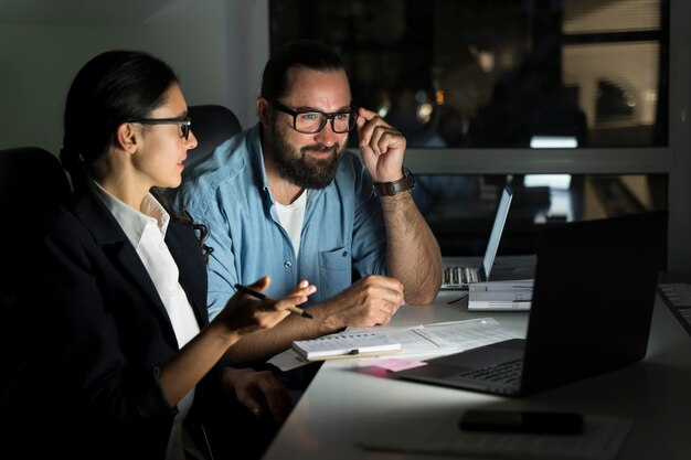 Compañeros de equipo de negocios trabajando hasta tarde