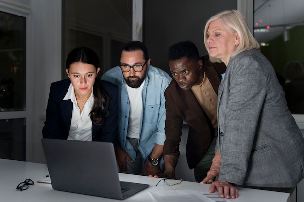 Foto gratuita compañeros de equipo trabajando hasta tarde en la oficina.