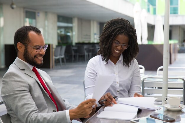 Compañeros de negocios multiétnicos que estudian informes