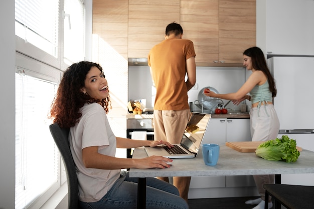 Compañeros de piso en la cocina plano medio