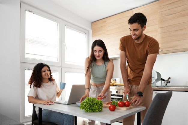 Foto gratuita compañeros de piso de tiro medio en la cocina