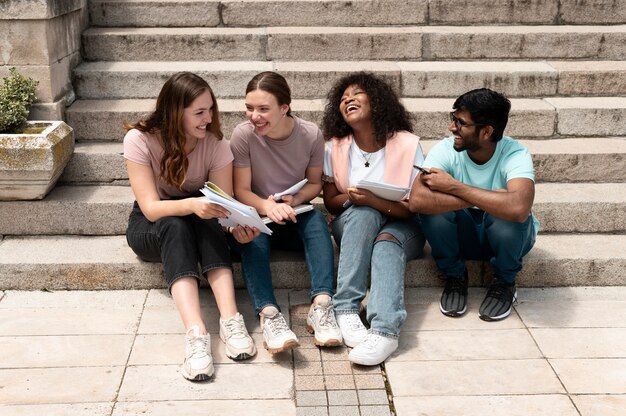 Compañeros que estudian juntos frente a su universidad antes de un examen