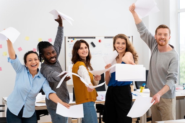 Compañeros sonrientes con hojas de papel plano medio