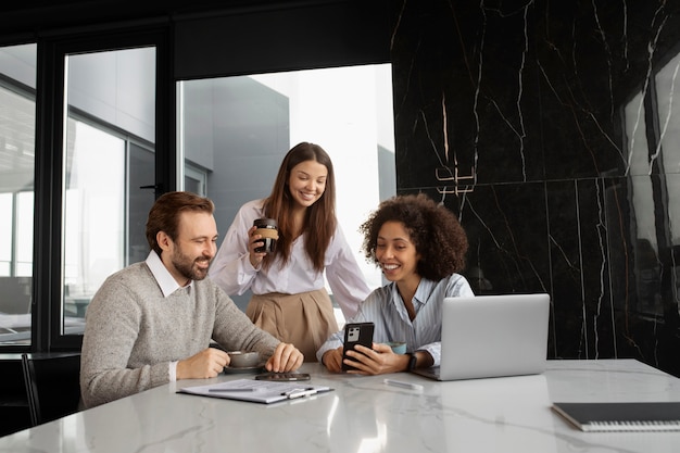 Compañeros sonrientes de tiro medio en el trabajo