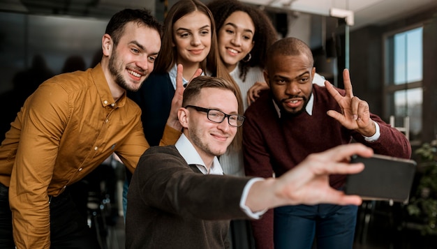 Compañeros sonrientes tomando un selfie durante una reunión