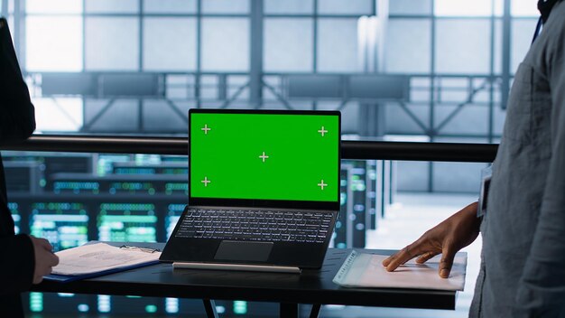 Compañeros de trabajo en un centro de datos que utilizan una maqueta de portátil que integra tecnologías verdes