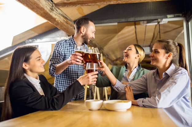 Foto gratuita compañeros de trabajo felices celebrando el evento corporativo después de un día de trabajo tenso.