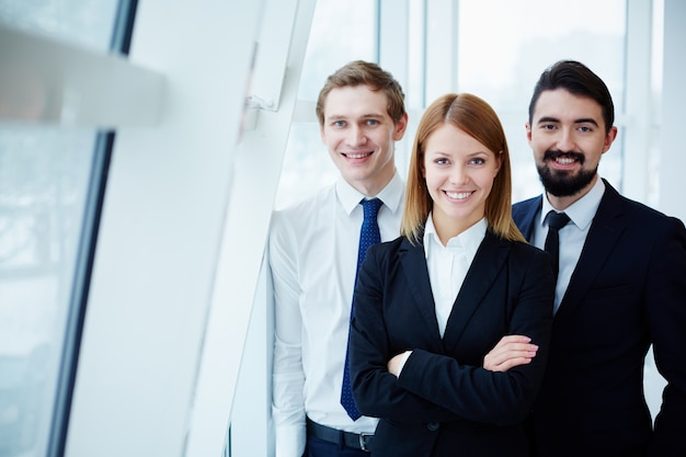 Foto gratuita compañeros de trabajo felices junto a la ventana