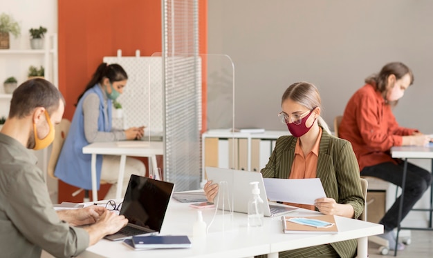 Compañeros de trabajo con mascarilla en el trabajo