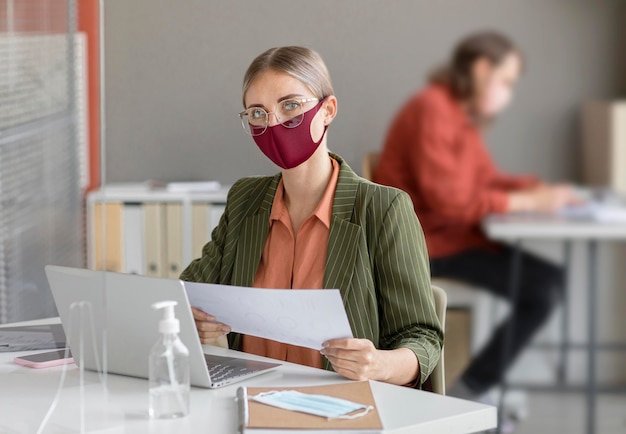 Foto gratuita compañeros de trabajo con mascarilla en el trabajo