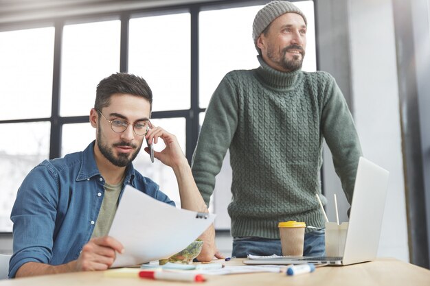 Compañeros de trabajo masculinos en la oficina con almuerzo