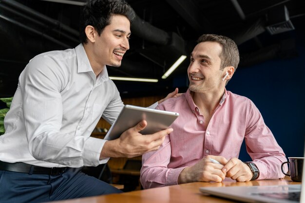 Compañeros de trabajo masculinos sonrientes conversando en el trabajo