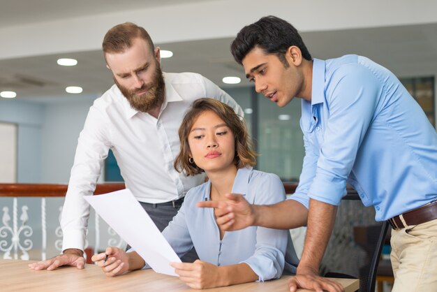 Compañeros de trabajo que ayudan al recién llegado a completar la solicitud de empleo