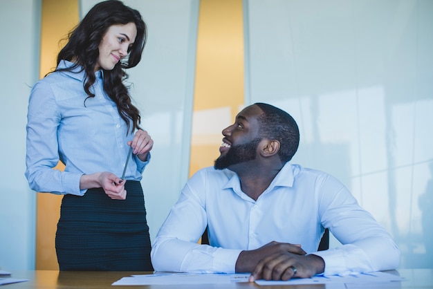 Compañeros de trabajo sonriendo uno al otro