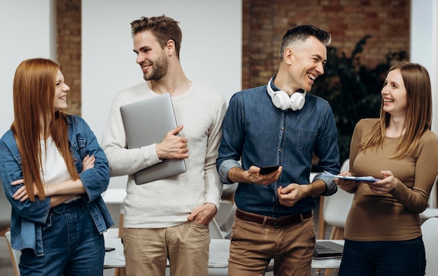 Foto gratuita compañeros de trabajo sonrientes hablando en la oficina