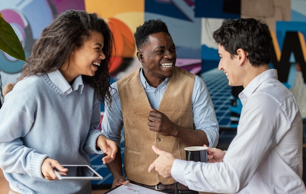 Foto gratuita compañeros de trabajo sonrientes en la oficina conversando