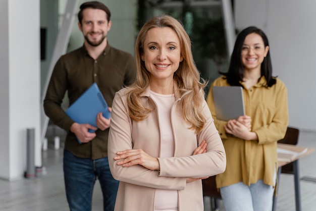 Compañeros de trabajo sonrientes posando juntos en la oficina