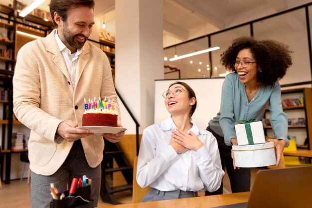 Compañeros de trabajo de tiro medio celebrando en la oficina