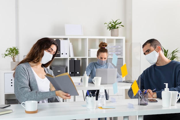 Compañeros de trabajo de tiro medio con máscaras