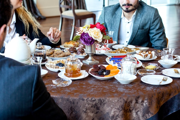 Los compañeros de trabajo toman té con frutas secas y nueces, dulces, mermeladas, baklava y galletas.