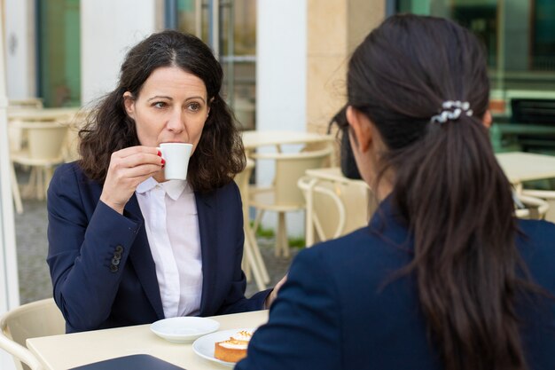Compañeros de trabajo tomando café en la cafetería al aire libre