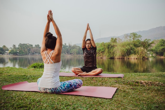 Compañeros de yoga sentados con las manos arriba