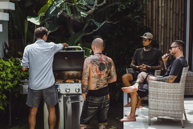 compañia de amigos cocinando parrilla al aire libre