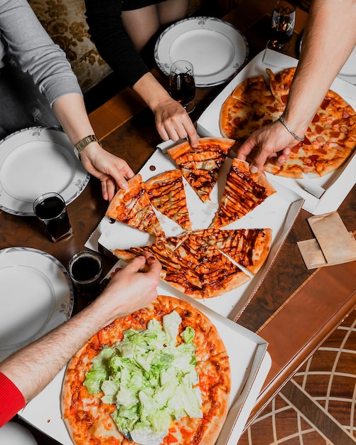 Foto gratuita compañía de amigos comiendo pizza y hablando