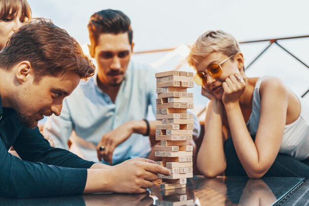 La compañía de jóvenes jugando juegos de mesa