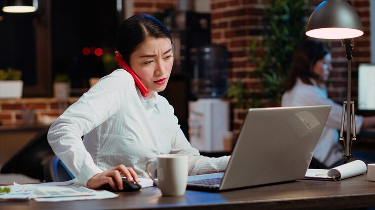 Photo Gratis company secretary taking phone call at office desk answering customer inquiries