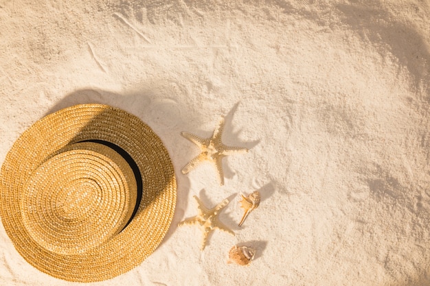 Composición con accesorio de verano y estrellas de mar sobre arena.