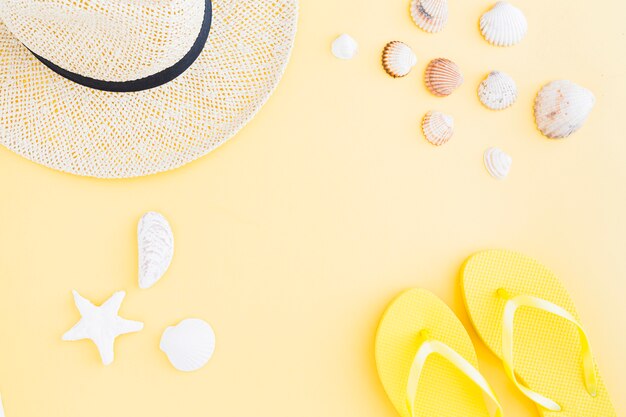 Composición de accesorios para vacaciones en la playa exótica sobre fondo amarillo.