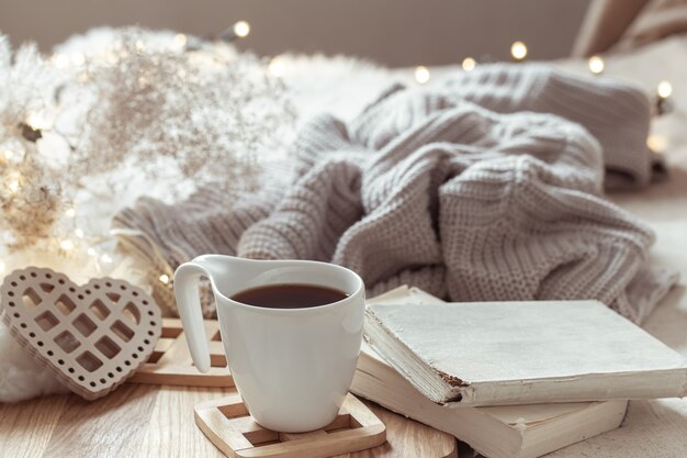 Composición acogedora con una taza de café en un platillo y detalles de decoración del hogar.