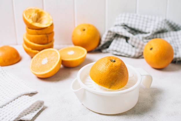 Foto gratuita composición de alto ángulo con naranjas a la mitad y exprimidor.